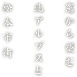 窓から望む北アルプスと松本市街